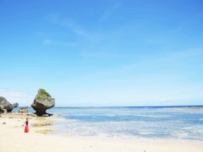沖縄のビーチに立つ溝端マリ